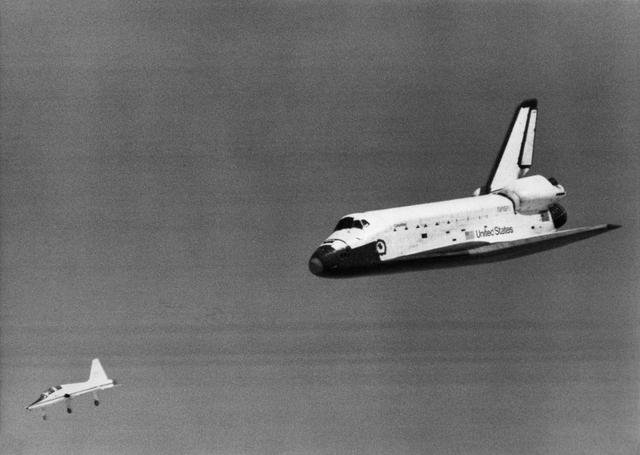 The Space Shuttle Columbia glides down over Rogers Dry Lake as it heads for a landing at Edwards AFB at the conclusion of its first orbital mission