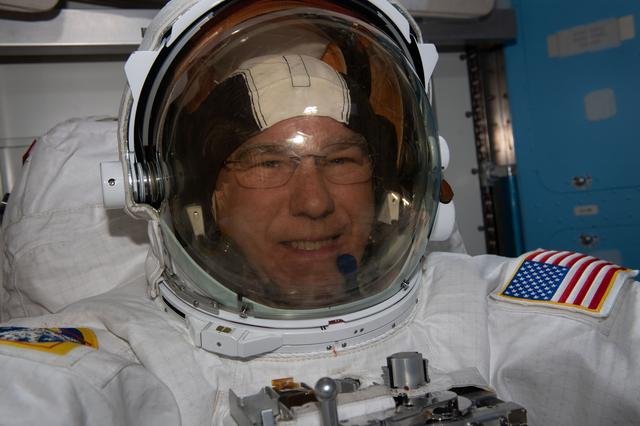 Astronaut Stephen Bowen tries on his spacesuit ahead of a spacewalk