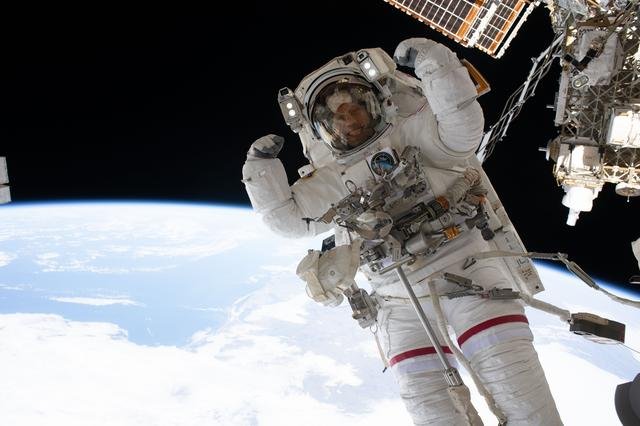 NASA astronaut Chris Williams playfully flexes for a portrait during a spacewalk