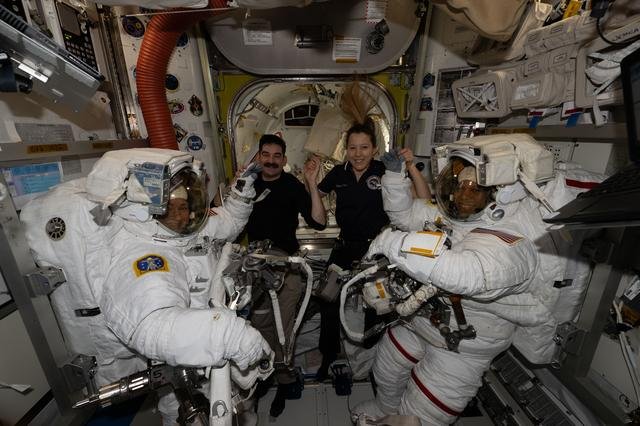 Astronauts assist spacewalkers into their spacesuits